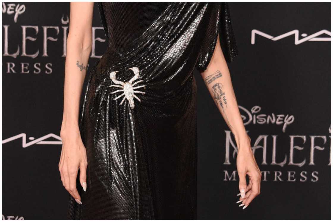 Angelina Jolie's Buddhist Swirl tattoo is seen as she arrives at the World Premiere Of Disney's "Maleficent: Mistress Of Evil" in Los Angeles, California. Angelina Jolie's Buddhist Swirl tattoo is seen as she arrives at the World Premiere Of Disney's "Maleficent: Mistress Of Evil" in Los Angeles, California.