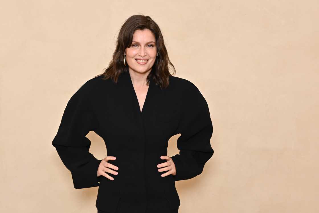 Laetitia Casta is standing next to a peach background in Paris, France