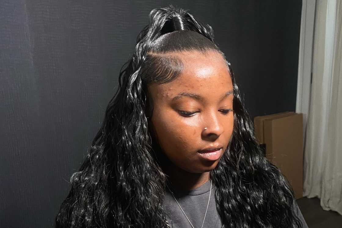 A woman is wearing a half up, half up down hairstyle A woman is wearing a half up, half up down hairstyle