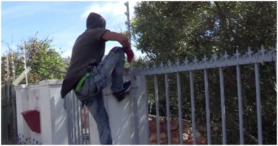 A burglar attempting to jump into a house