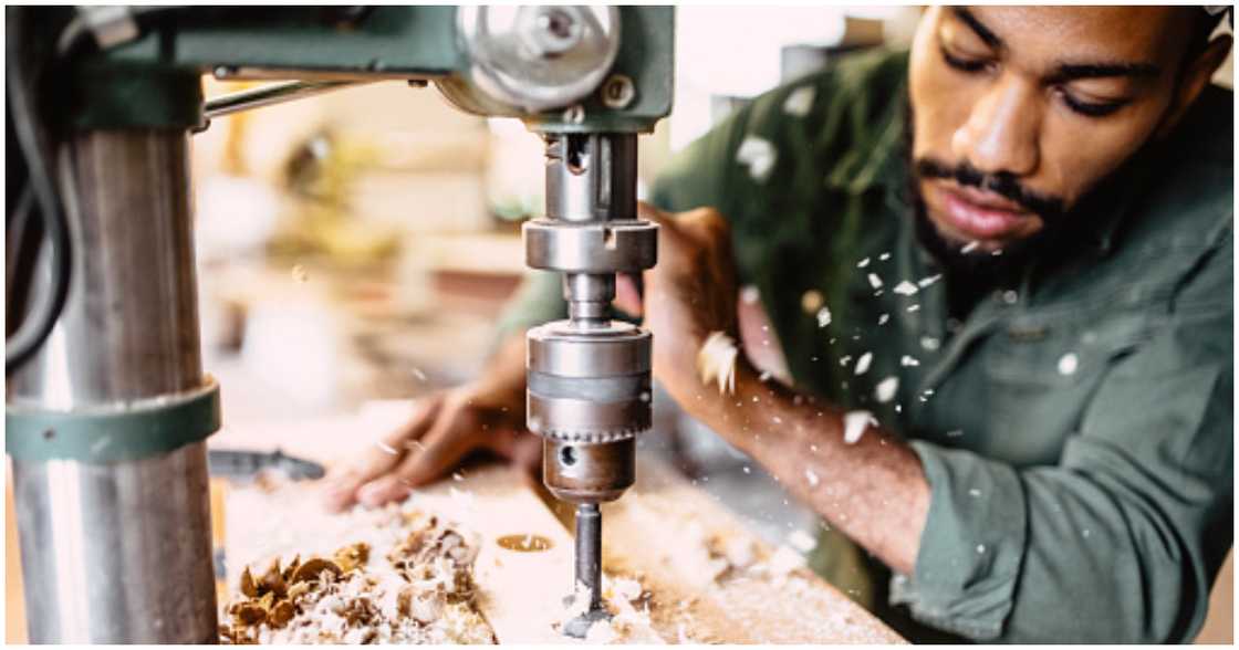 A man drills holes in wood A man drills holes in wood
