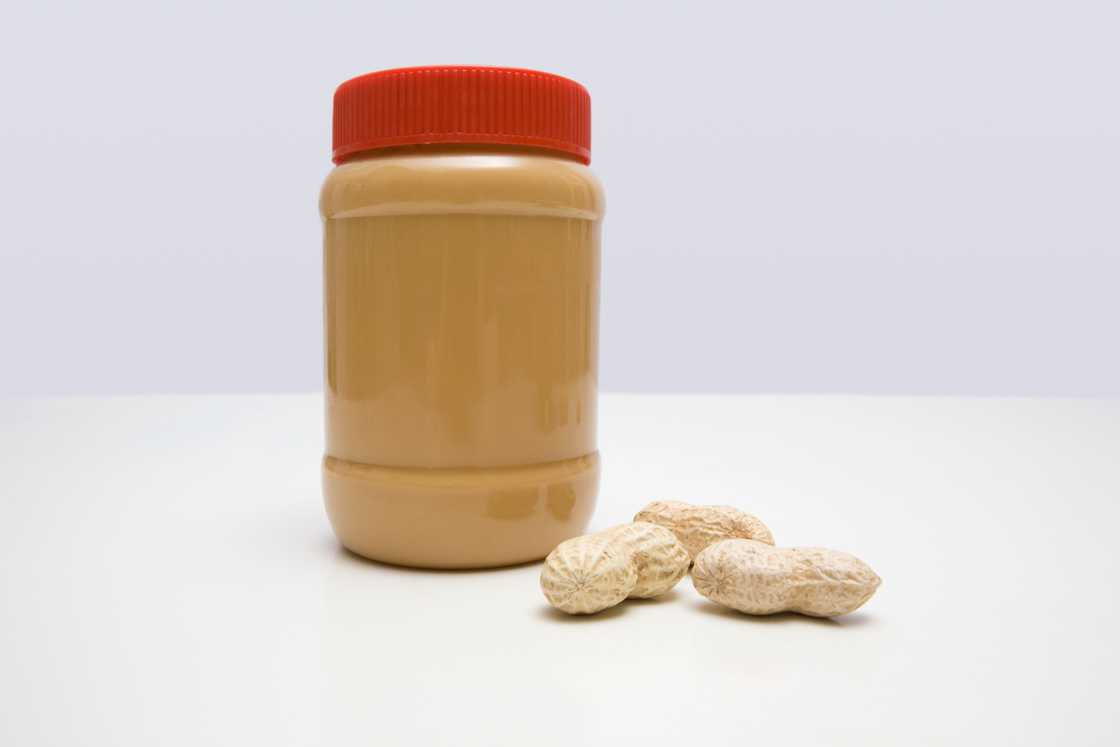 A jar of peanut butter and peanuts A jar of peanut butter and peanuts