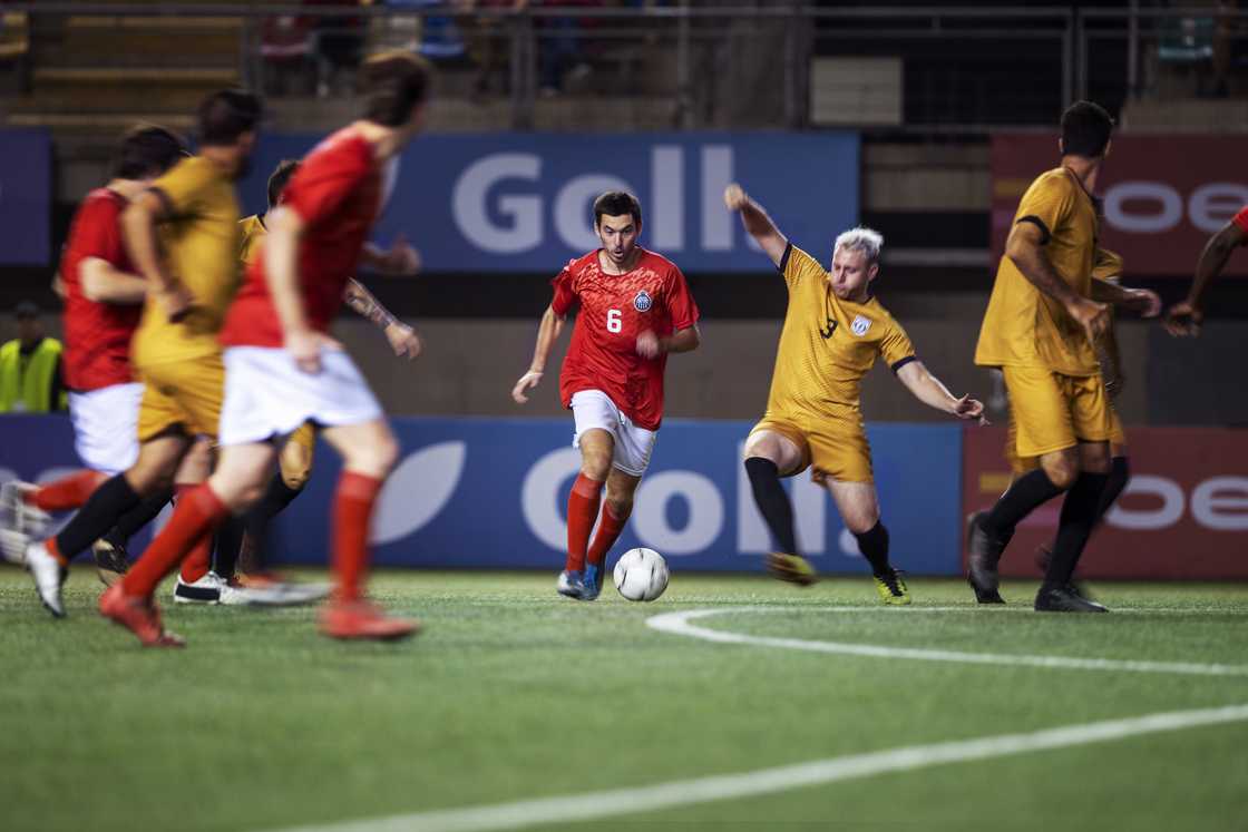 Soccer players engaged in a match on a field.