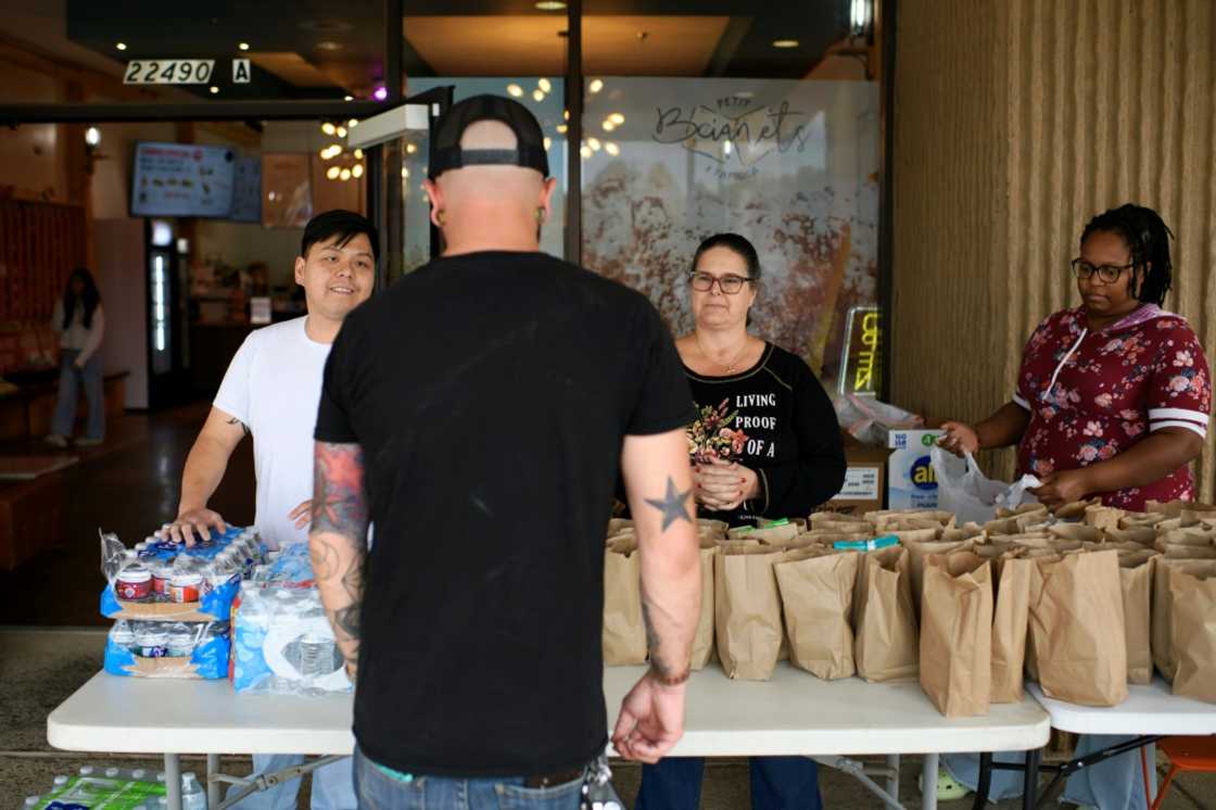 Eric Dunham (Center) is one of several Houston residents receiving free lunch bags at a restaurant in the Texas metropolis as funding lapses for the US program that provides food benefits for millions of Americans Eric Dunham (Center) is one of several Houston residents receiving free lunch bags at a restaurant in the Texas metropolis as funding lapses for the US program that provides food benefits for millions of Americans
