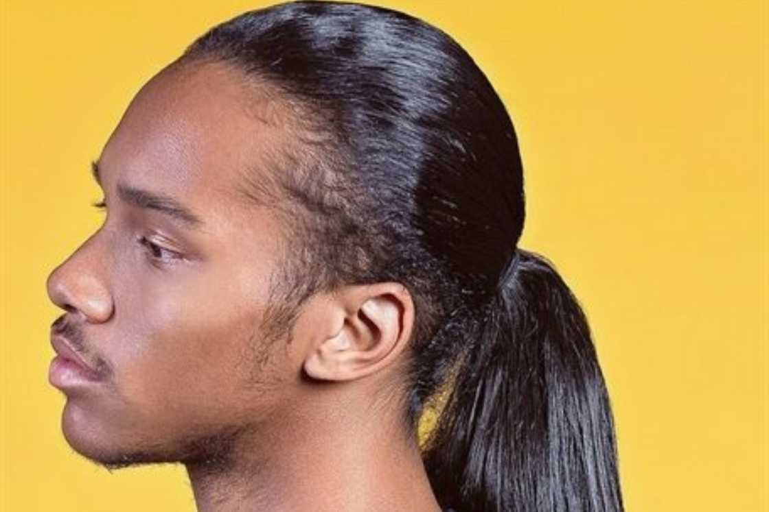 A man rocks a sleek low ponytail A man rocks a sleek low ponytail