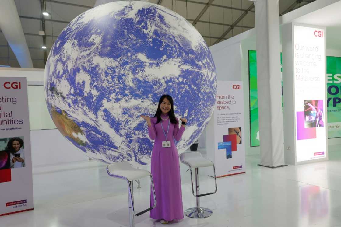 A delegate poses for a picture in an exhibitions pavilion at the convention center hosting the COP27 climate conference A delegate poses for a picture in an exhibitions pavilion at the convention center hosting the COP27 climate conference