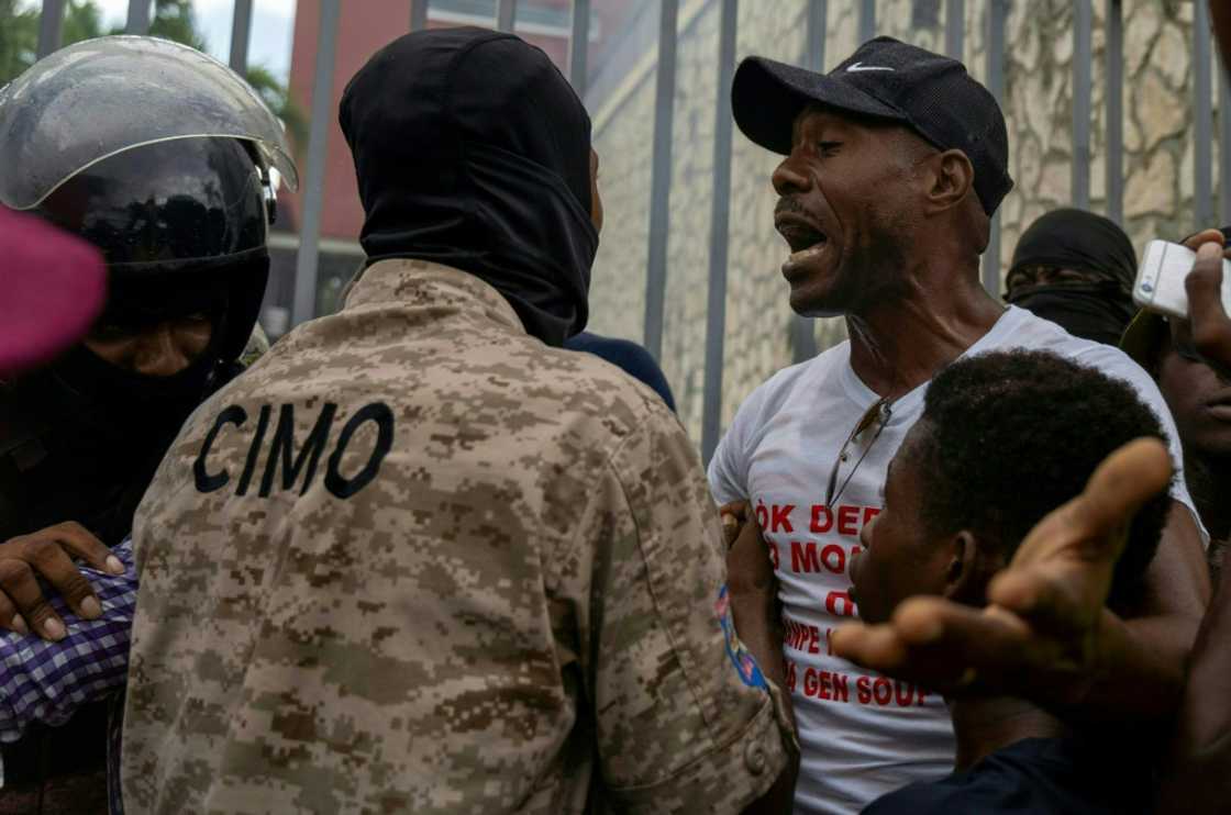 A man argues with a policeman outside the Canadian embassy during a protest in Port-au-Prince, Haiti, on October 24, 2022 A man argues with a policeman outside the Canadian embassy during a protest in Port-au-Prince, Haiti, on October 24, 2022