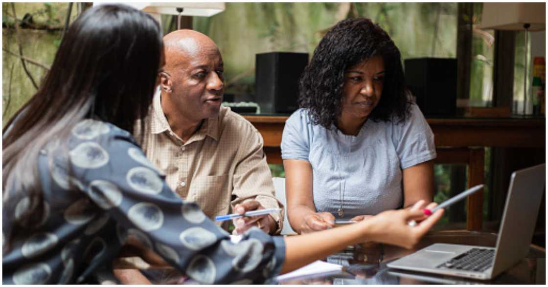 A couple listens attentively as a professional talks to them about mortgages