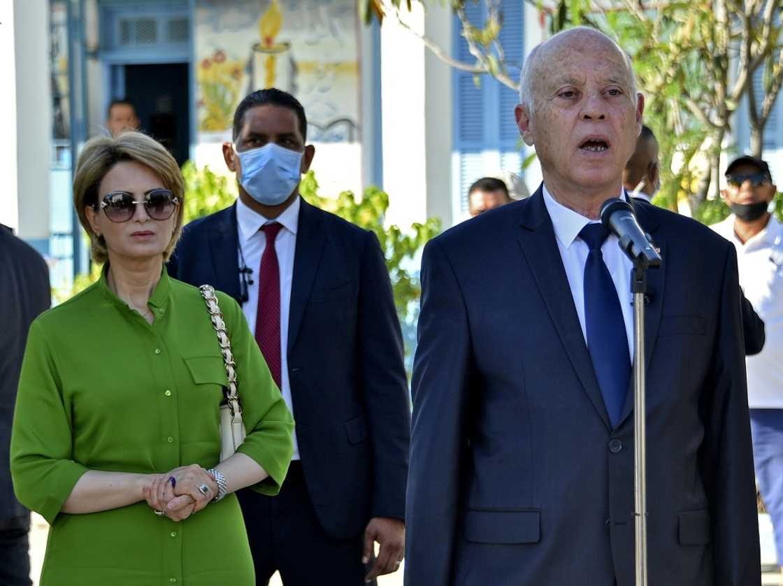 Tunisian President Kais Saied speaks after voting with his wife Ichraf Chebil