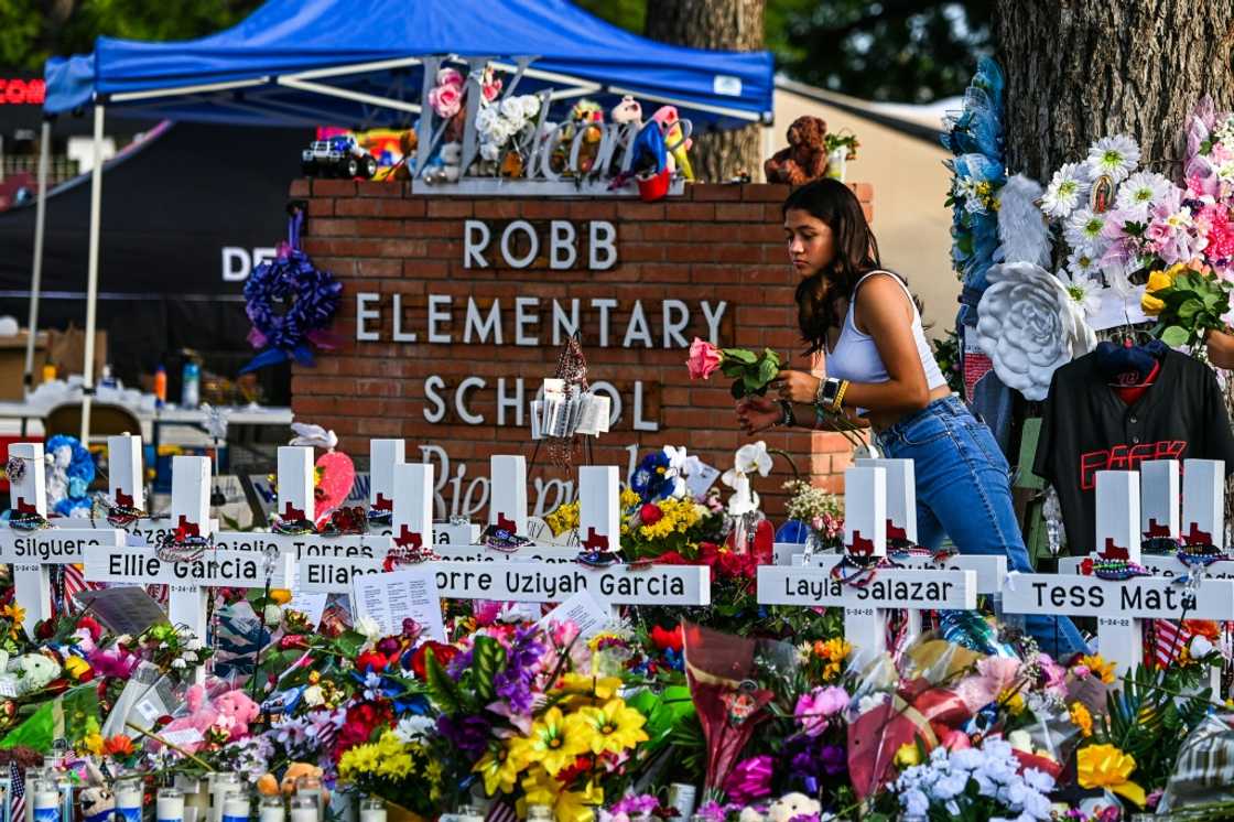 A girl lays flowers at a makeshift memorial at Robb Elementary School in Uvalde, Texas in May 2022 A girl lays flowers at a makeshift memorial at Robb Elementary School in Uvalde, Texas in May 2022