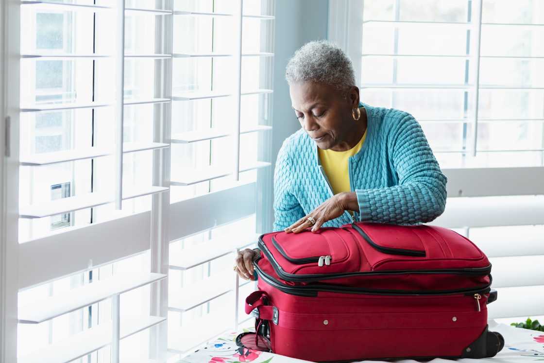 A senior woman with suitcase