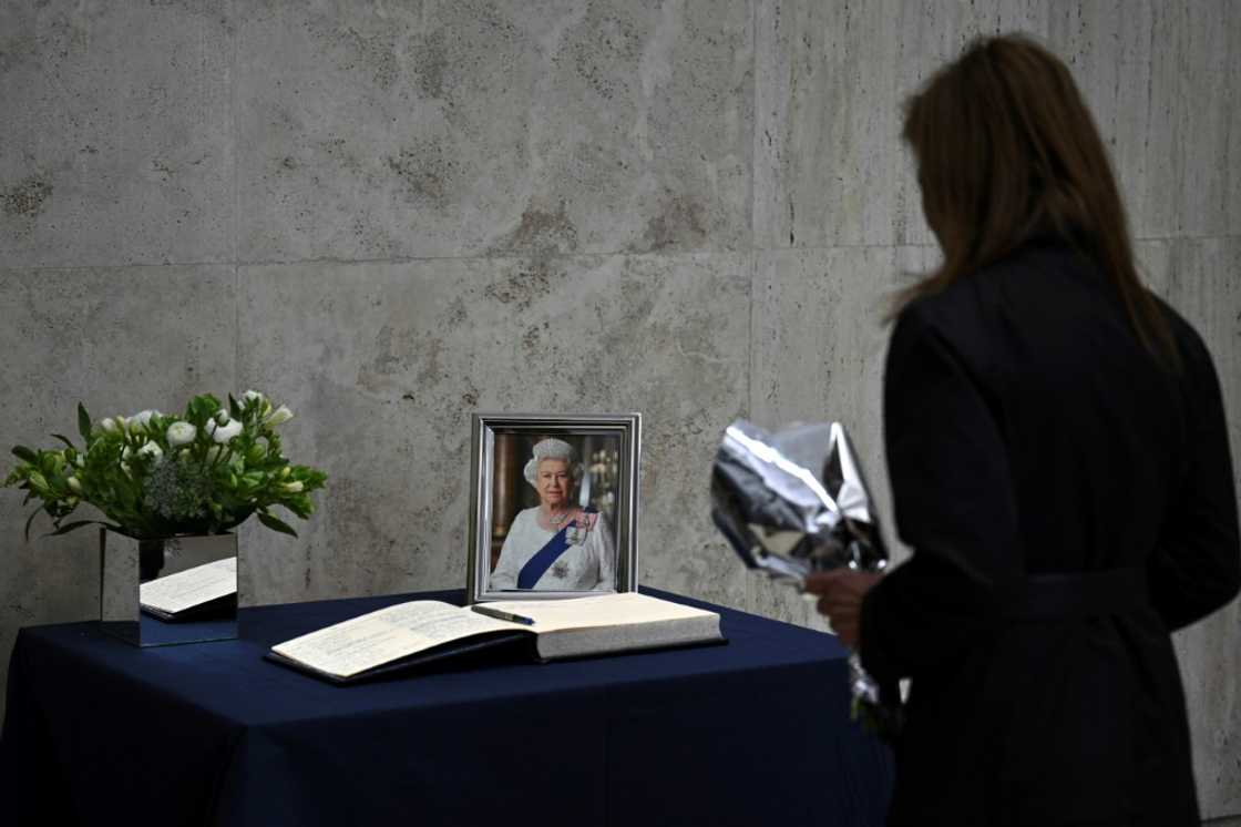 Una mujer rinde homenaje a la reina Isabel II con un ramo de flores y un mensaje en el libro de condolencias de la embajada británica en Buenos Aires, el 9 de septiembre de 2022 Una mujer rinde homenaje a la reina Isabel II con un ramo de flores y un mensaje en el libro de condolencias de la embajada británica en Buenos Aires, el 9 de septiembre de 2022