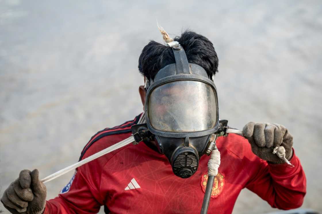 A diver in Myanmar works to recover a sunken ship in the Yangon River, plunging down to attach cables to the wreck and using the power of the tides to bring the boat to shore