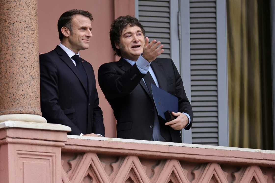 France's President Emmanuel Macron (L) and Argentina's President Javier Milei talk on the balcony of the Casa Rosada government palace after a meeting in Buenos Aires on November 17, 2024.