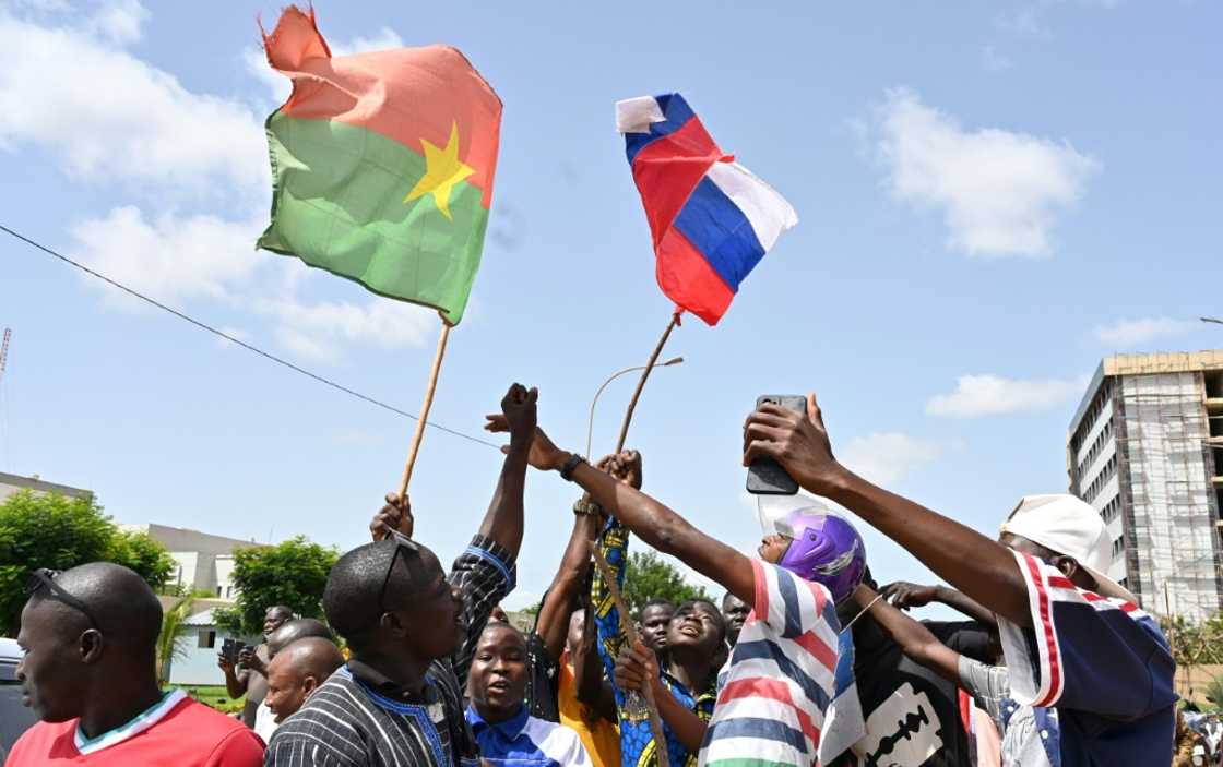 A small group of protesters wave Russian and Burkina Faso flags in Ouagadougou after a new coup A small group of protesters wave Russian and Burkina Faso flags in Ouagadougou after a new coup