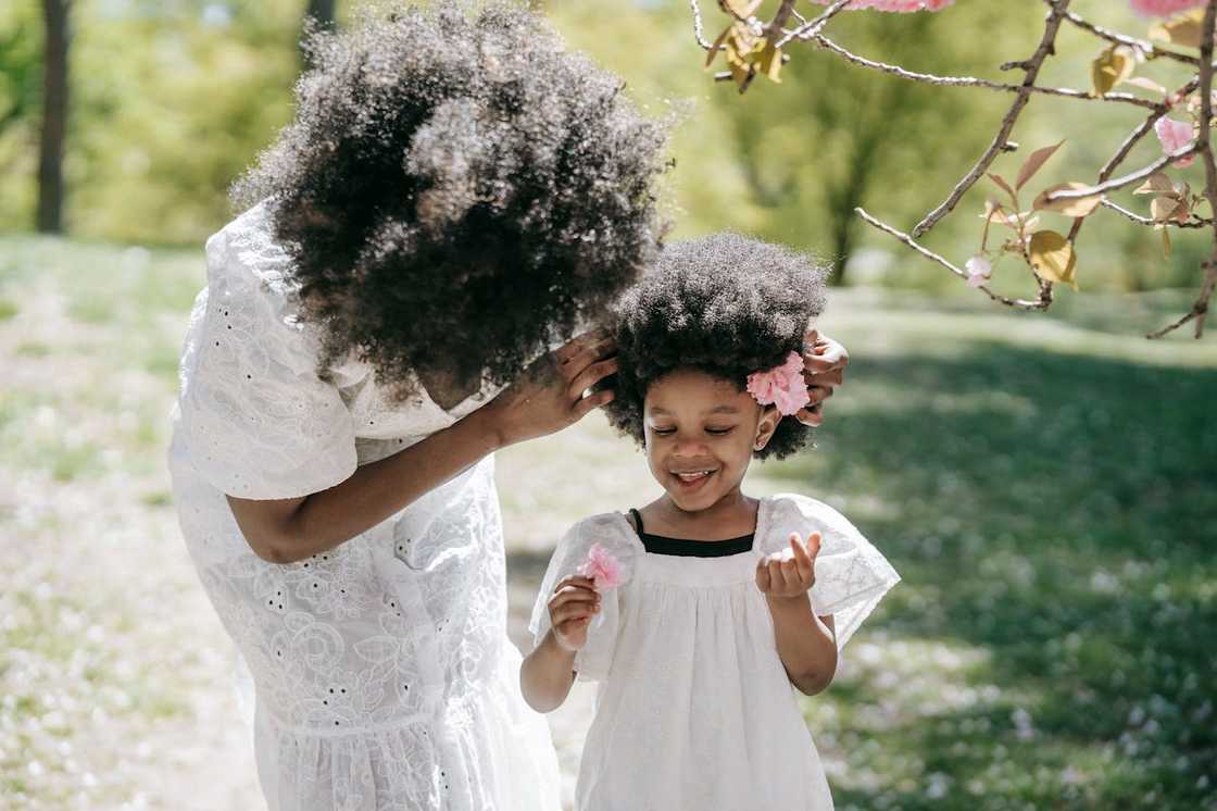 A woman plays with her daughter in the park.