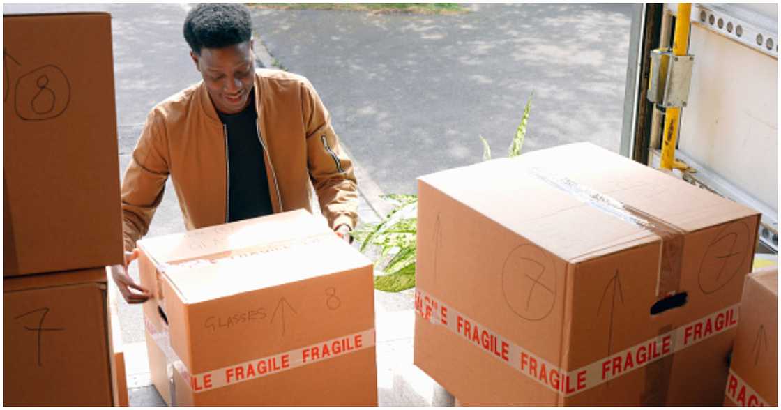 A young man packs his belongings into a mover's truck