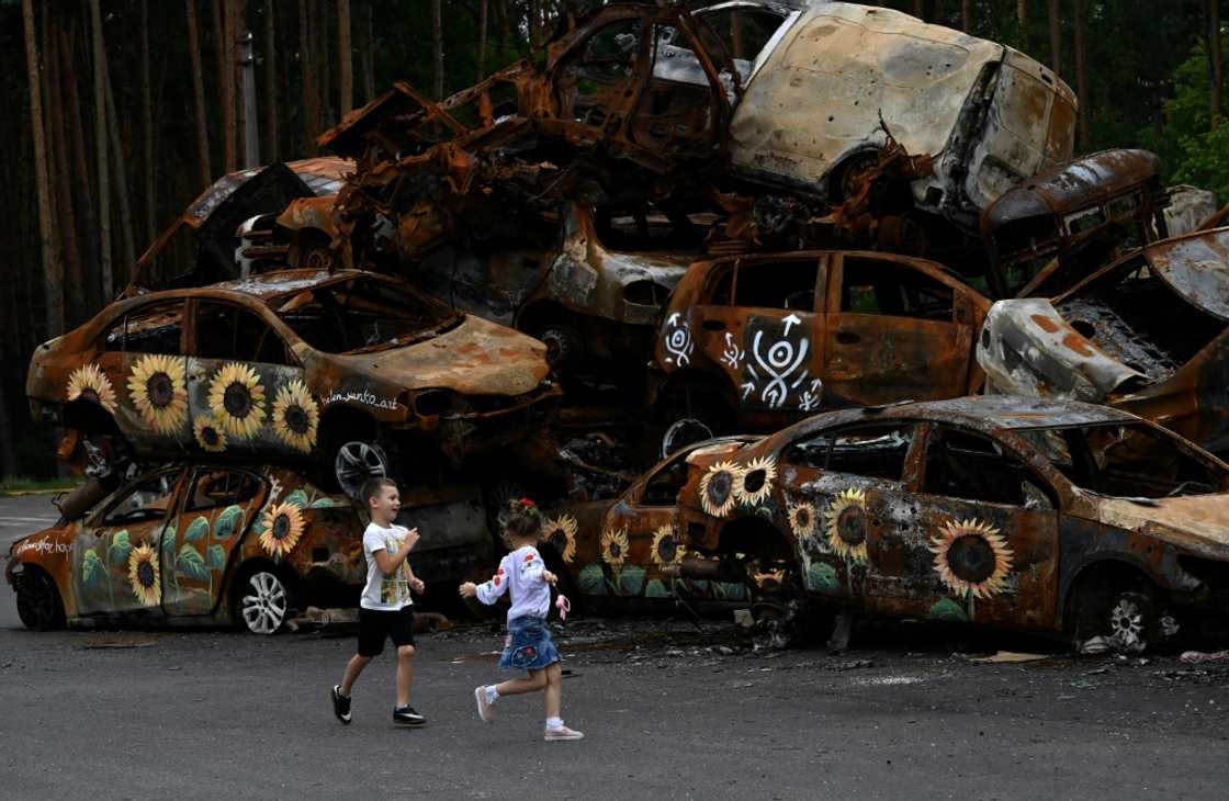 Children play at a symbolic cemetery of cars shot by Russian troops in Irpin near Kyiv Children play at a symbolic cemetery of cars shot by Russian troops in Irpin near Kyiv