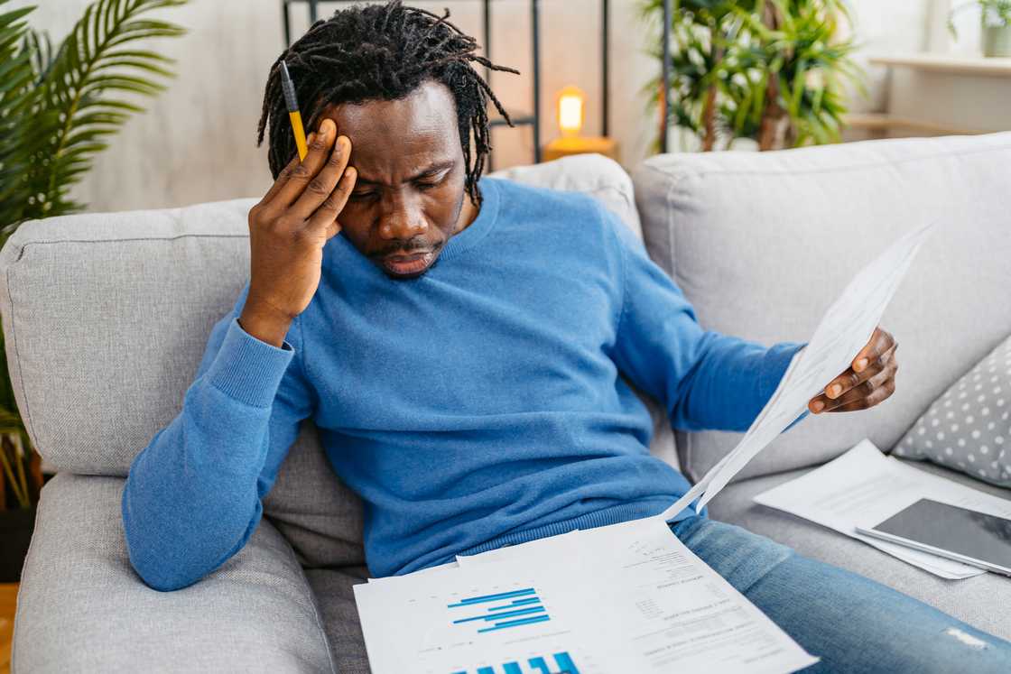 A stressed man going through his bills