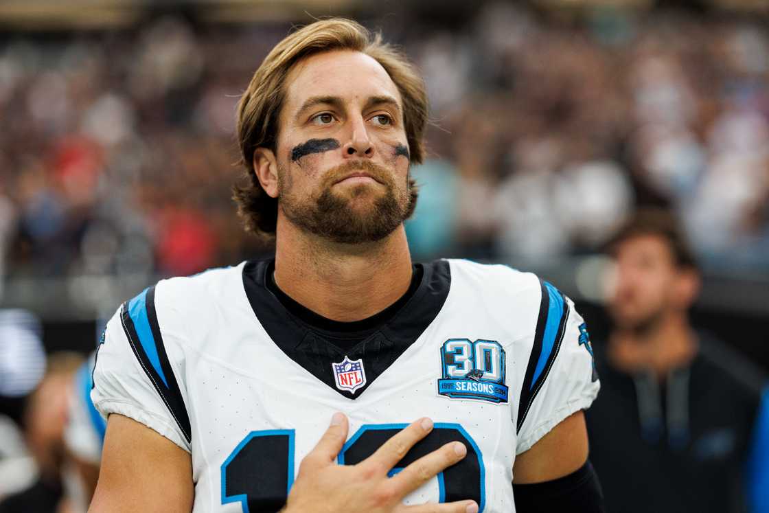 Adam Thielen stands on the sidelines during the national anthem before an NFL football game