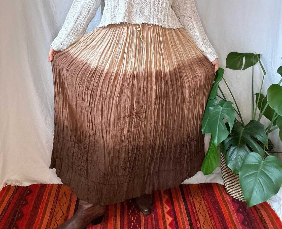 A woman shows off her brown broomstick skirt A woman shows off her brown broomstick skirt