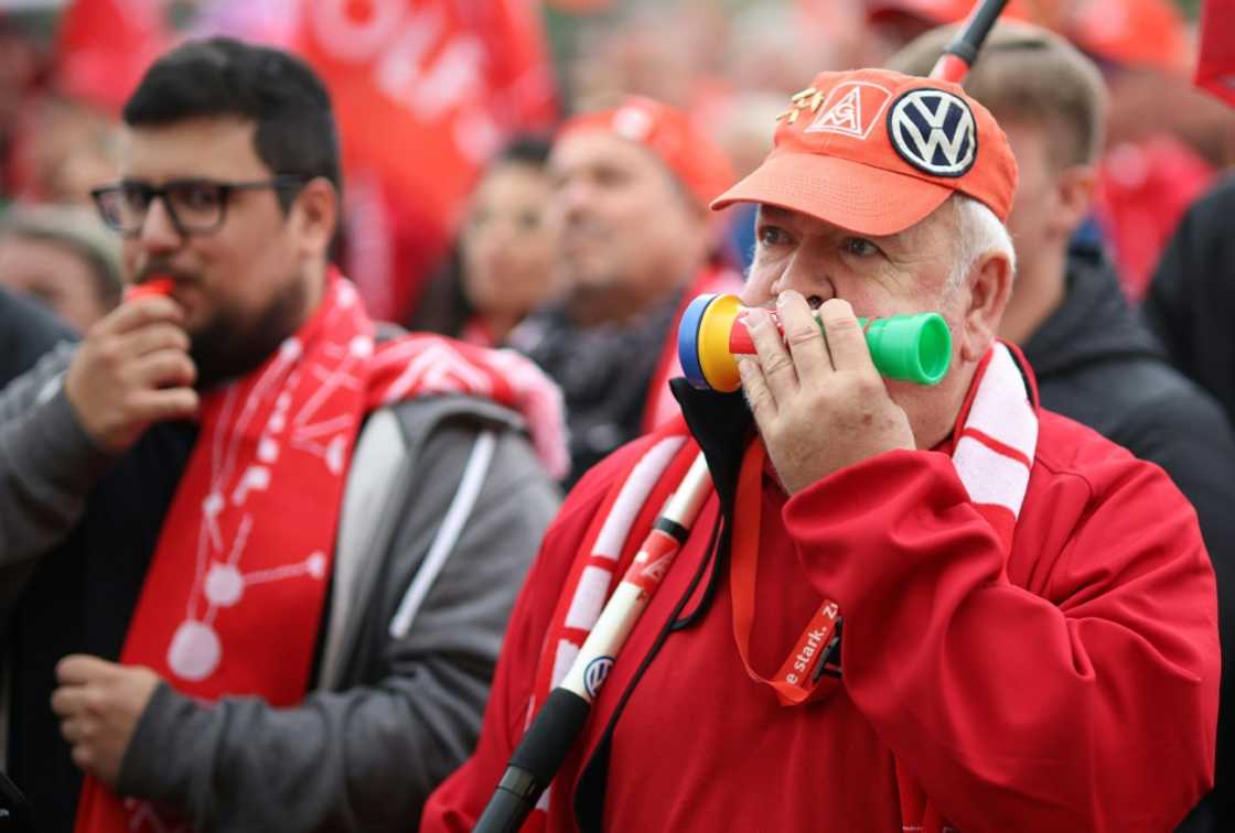 A protester wears the logos of metalworkers' union IG Metall and German carmaker Volkswagen on his cap