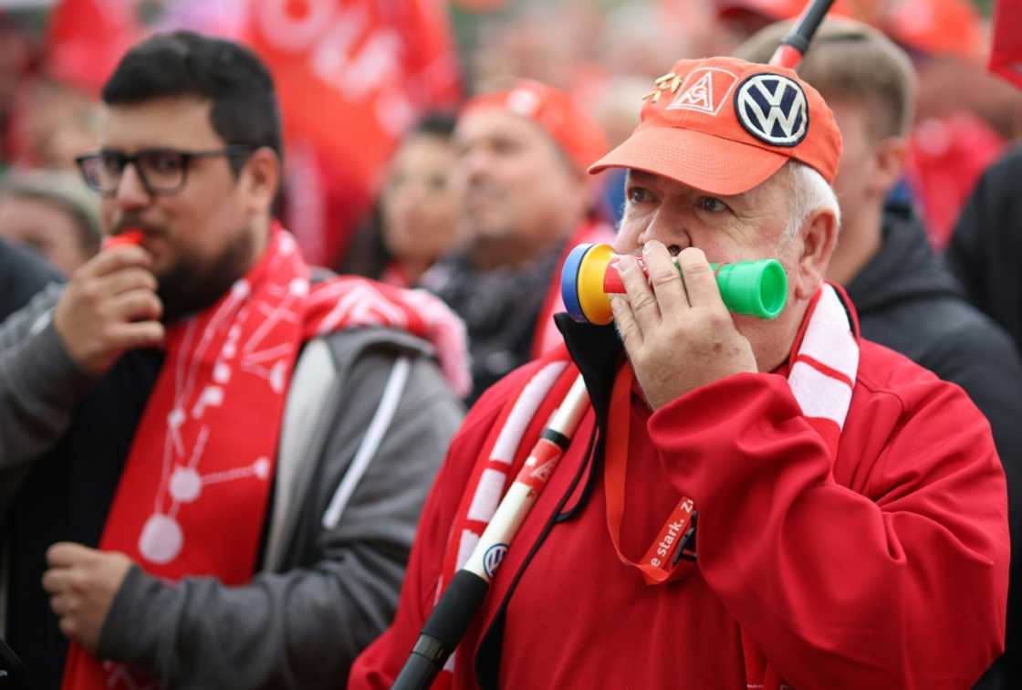 A protester wears the logos of the IG Metall metalworkers union and of German car maker Volkswagen on his cap A protester wears the logos of the IG Metall metalworkers union and of German car maker Volkswagen on his cap