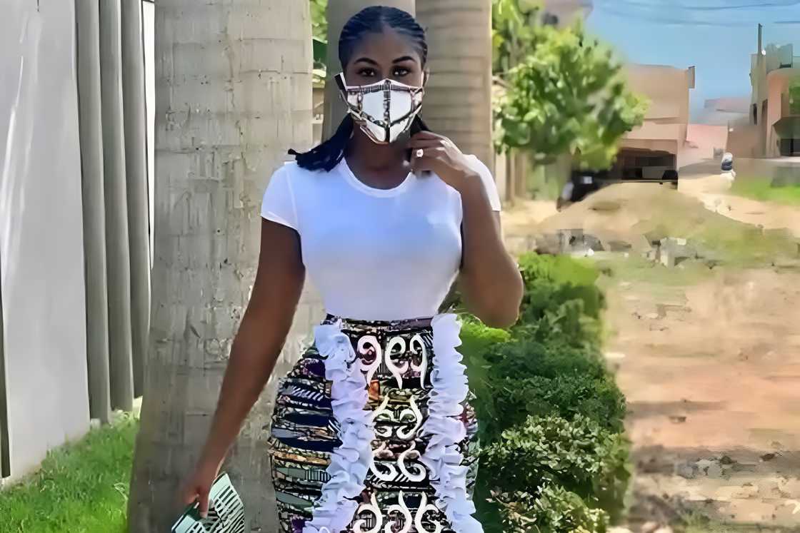 A woman with a white t-shirt and ankara skirt