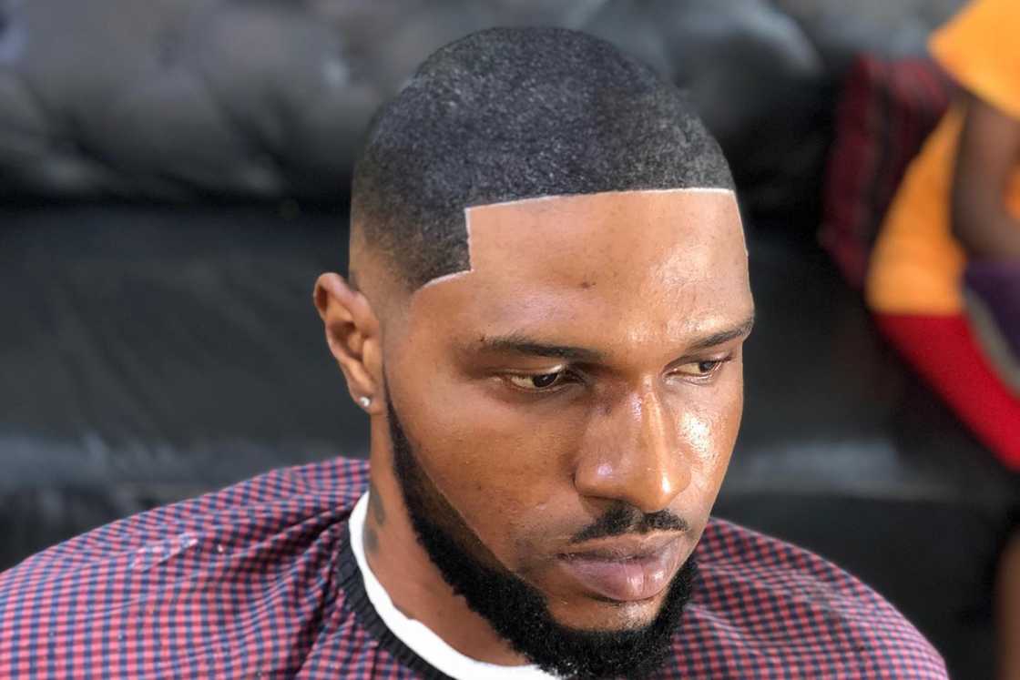 An African man in a barbershop after a shave An African man in a barbershop after a shave