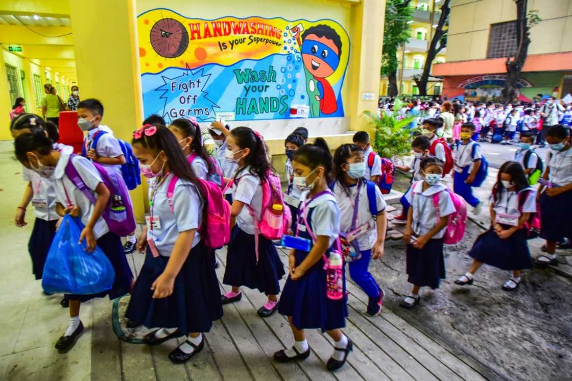 Children in masks and uniforms are returning to Pedro Guevara Elementary School in Manila, which had shut classrooms since March 2020 Children in masks and uniforms are returning to Pedro Guevara Elementary School in Manila, which had shut classrooms since March 2020