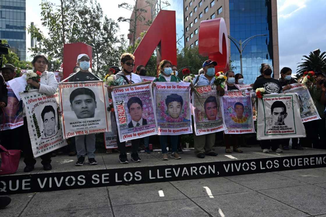 Relatives carry pictures of some of the 43 Mexican students who disappeared in 2014, at a march marking the eighth anniversary of the tragedy Relatives carry pictures of some of the 43 Mexican students who disappeared in 2014, at a march marking the eighth anniversary of the tragedy