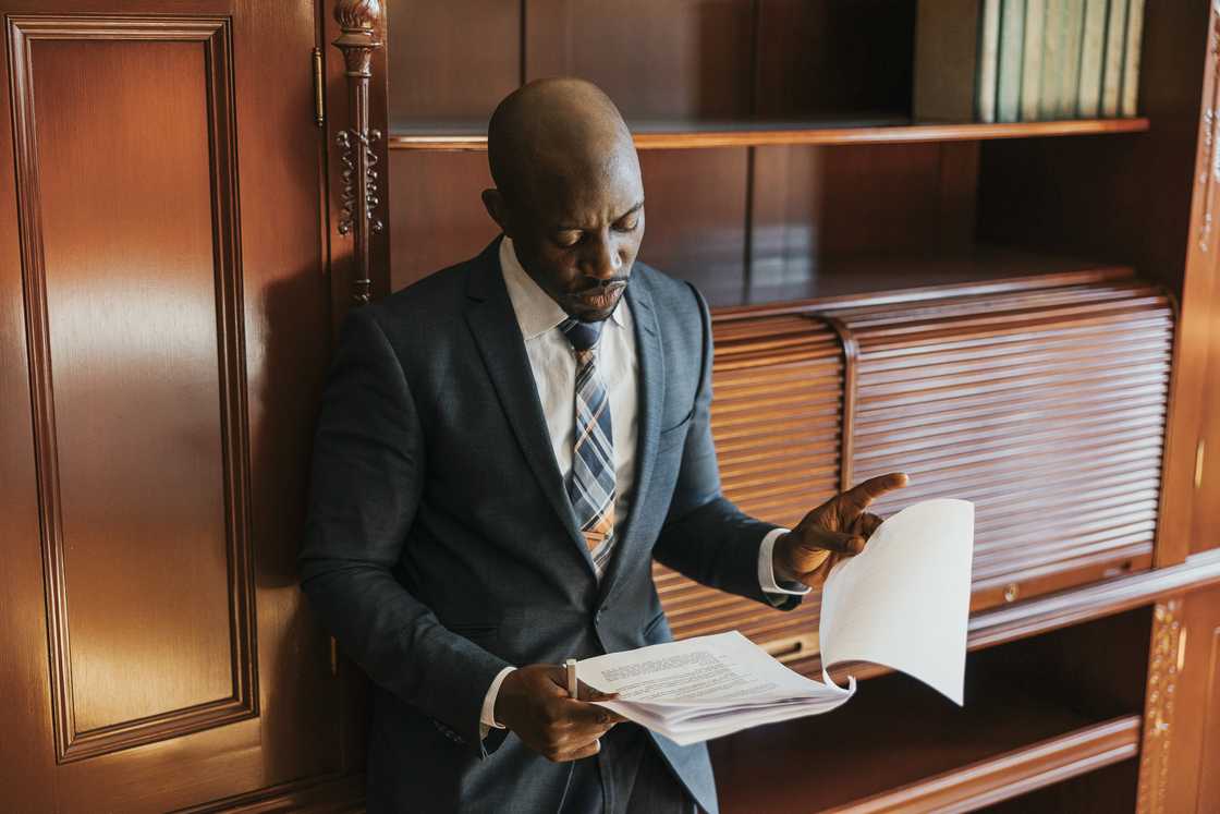 A lawyer reads the will to the benefactors.