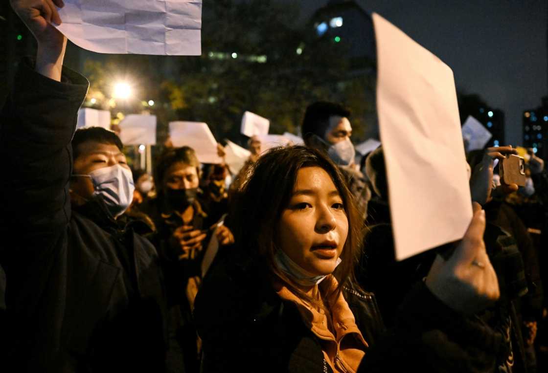 Protesters march along a street during a rally for the victims of a deadly fire as well as a protest against China's harsh Covid-19 restrictions Protesters march along a street during a rally for the victims of a deadly fire as well as a protest against China's harsh Covid-19 restrictions
