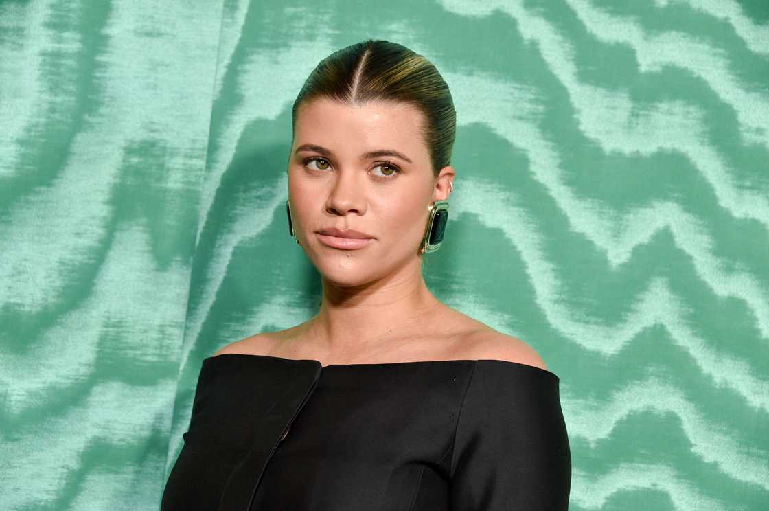 Sofia Richie is standing next to a green curtain in Los Angeles, California