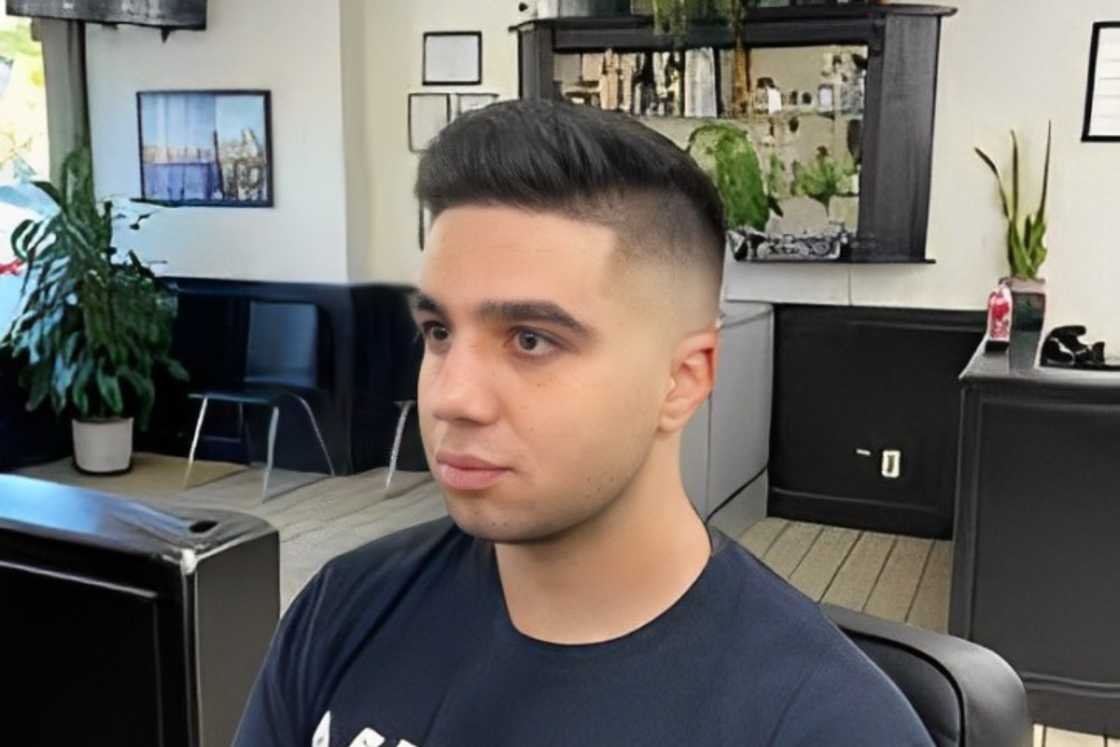 A man with a mid fade with a long fohawk on top