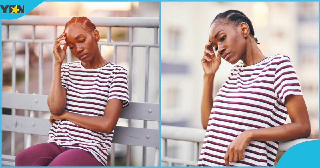 Photo of a young lady looking seated alone looking sad.