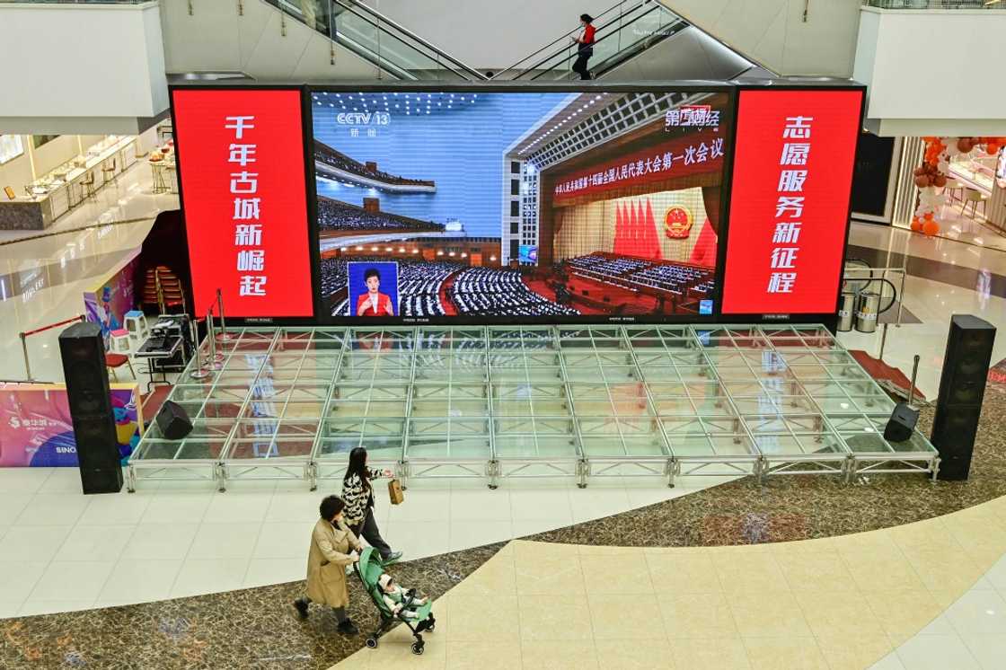 Live coverage of the opening session of the National People's Congress (NPC) is shown at a shopping mall in Qingzhou, China Live coverage of the opening session of the National People's Congress (NPC) is shown at a shopping mall in Qingzhou, China