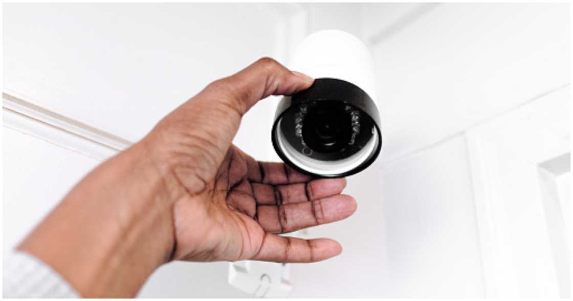 Woman adjusts security camera Woman adjusts security camera