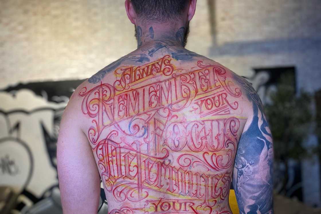 A man with a full back text tattoo A man with a full back text tattoo