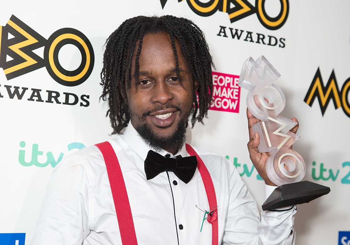 Popcaan holding an award