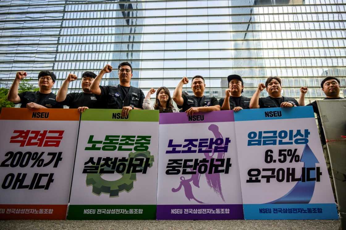 Samsung Electronics' union members hold placards during a rally outside the company building in Seoul Samsung Electronics' union members hold placards during a rally outside the company building in Seoul