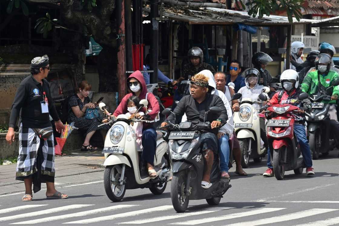 A security officer manages traffic as the motorcade of US President Joe Biden passes by during the G20 summit in Nusa Dua on the Indonesian resort island of Bali