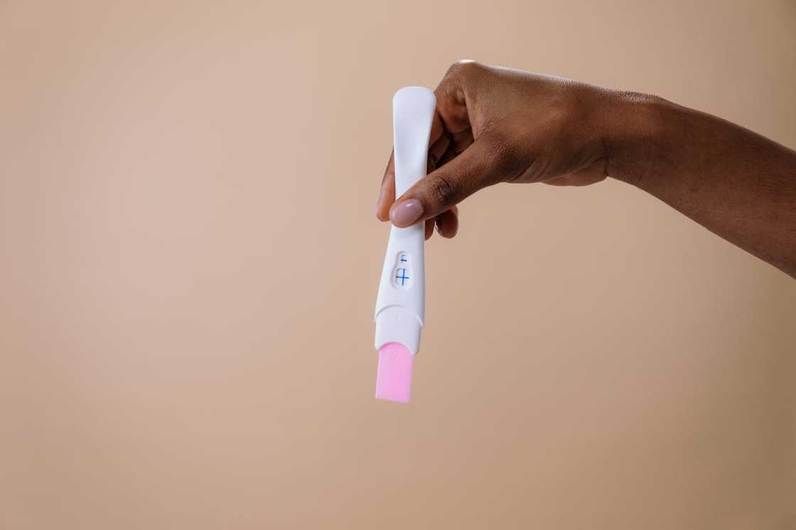 A woman holds a positive pregnancy test.
