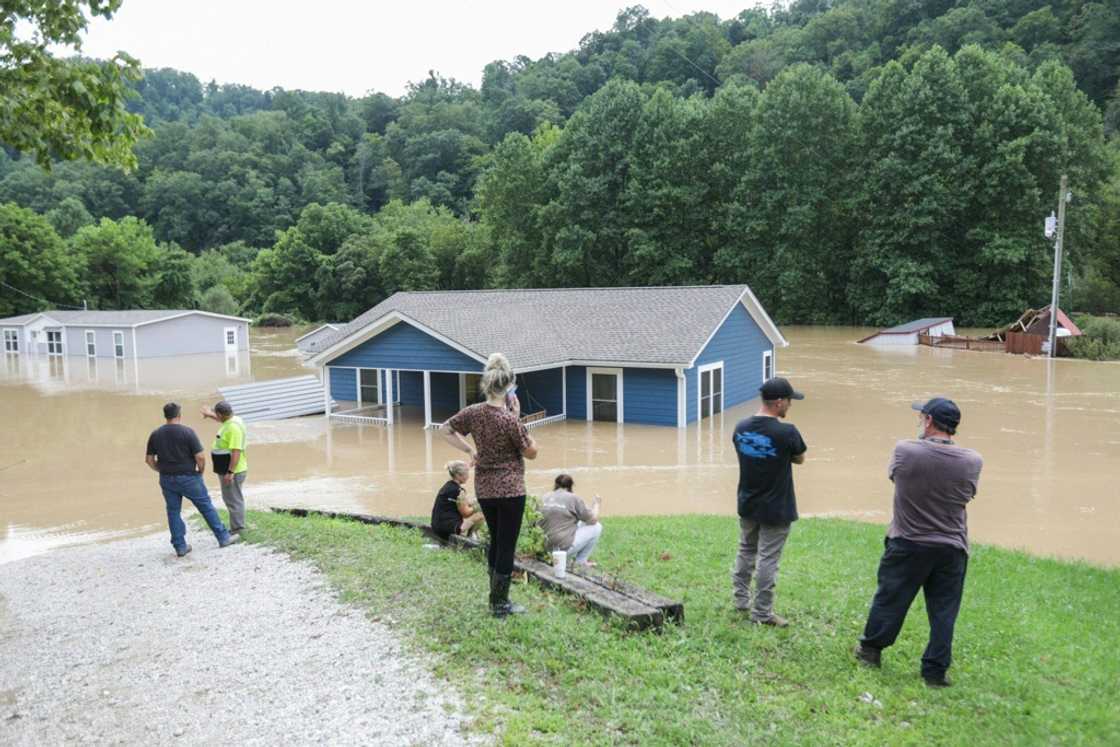A family looks at their submerged home in Jackson, Kentucky A family looks at their submerged home in Jackson, Kentucky