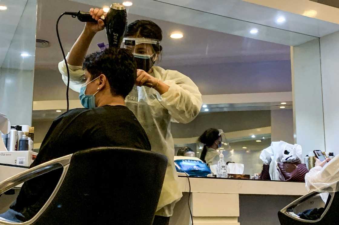 In this file photo taken on June 21, 2020, a hairdresser blow-dries a client's hair at a women's beauty centre in Riyadh as the country begins to re-open following the lifting of a coronavirus lockdown In this file photo taken on June 21, 2020, a hairdresser blow-dries a client's hair at a women's beauty centre in Riyadh as the country begins to re-open following the lifting of a coronavirus lockdown