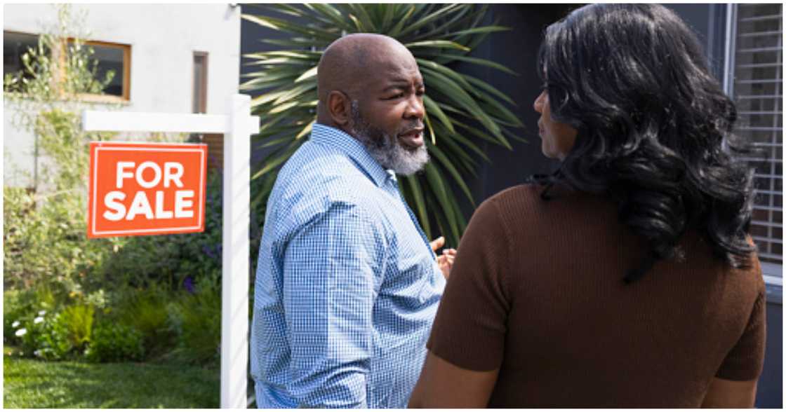A woman contemplates buying a house A woman contemplates buying a house