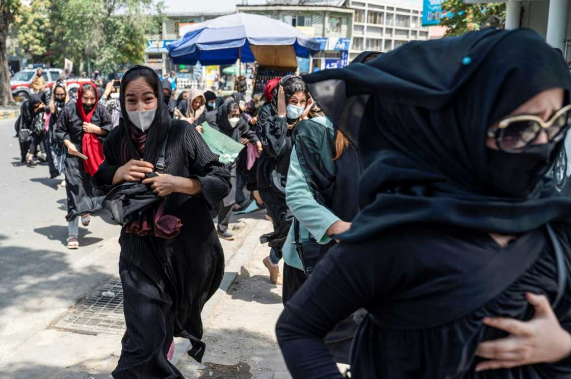 Women run for cover after Taliban fighters beat them and fired into the air to disperse a protest march called to demand their rights Women run for cover after Taliban fighters beat them and fired into the air to disperse a protest march called to demand their rights