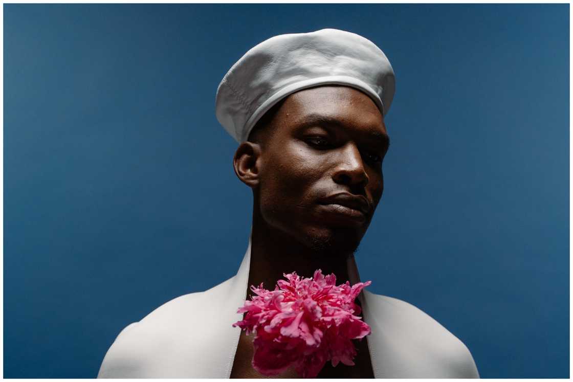 A black male model posing with pink flowers A black male model posing with pink flowers