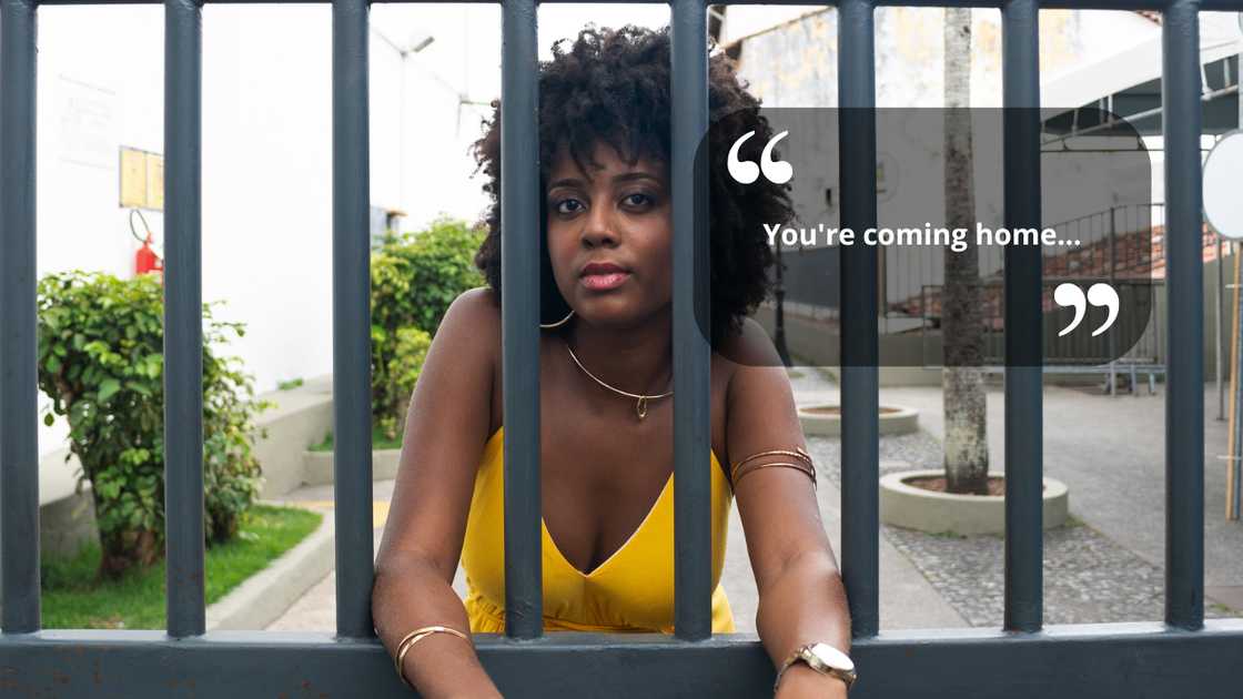 A woman standing outside an iron gate