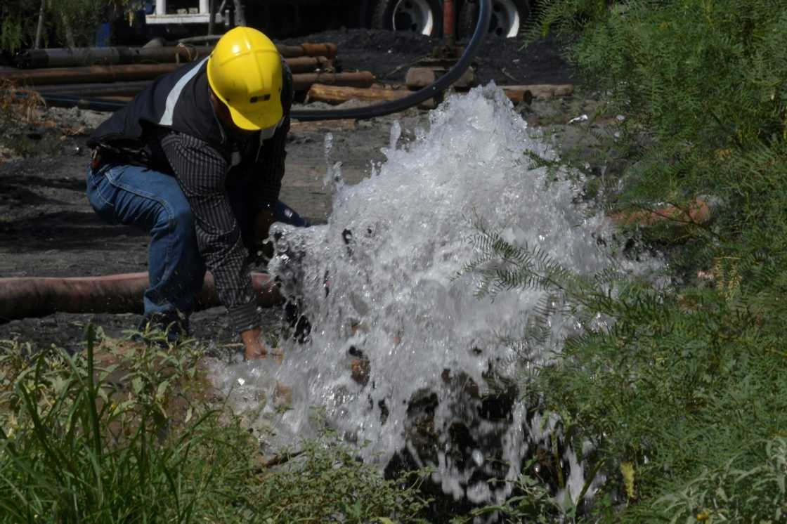 A rescuer works with a hose at a flooded mine in northern Mexico where 10 workers have been trapped for more than a week A rescuer works with a hose at a flooded mine in northern Mexico where 10 workers have been trapped for more than a week